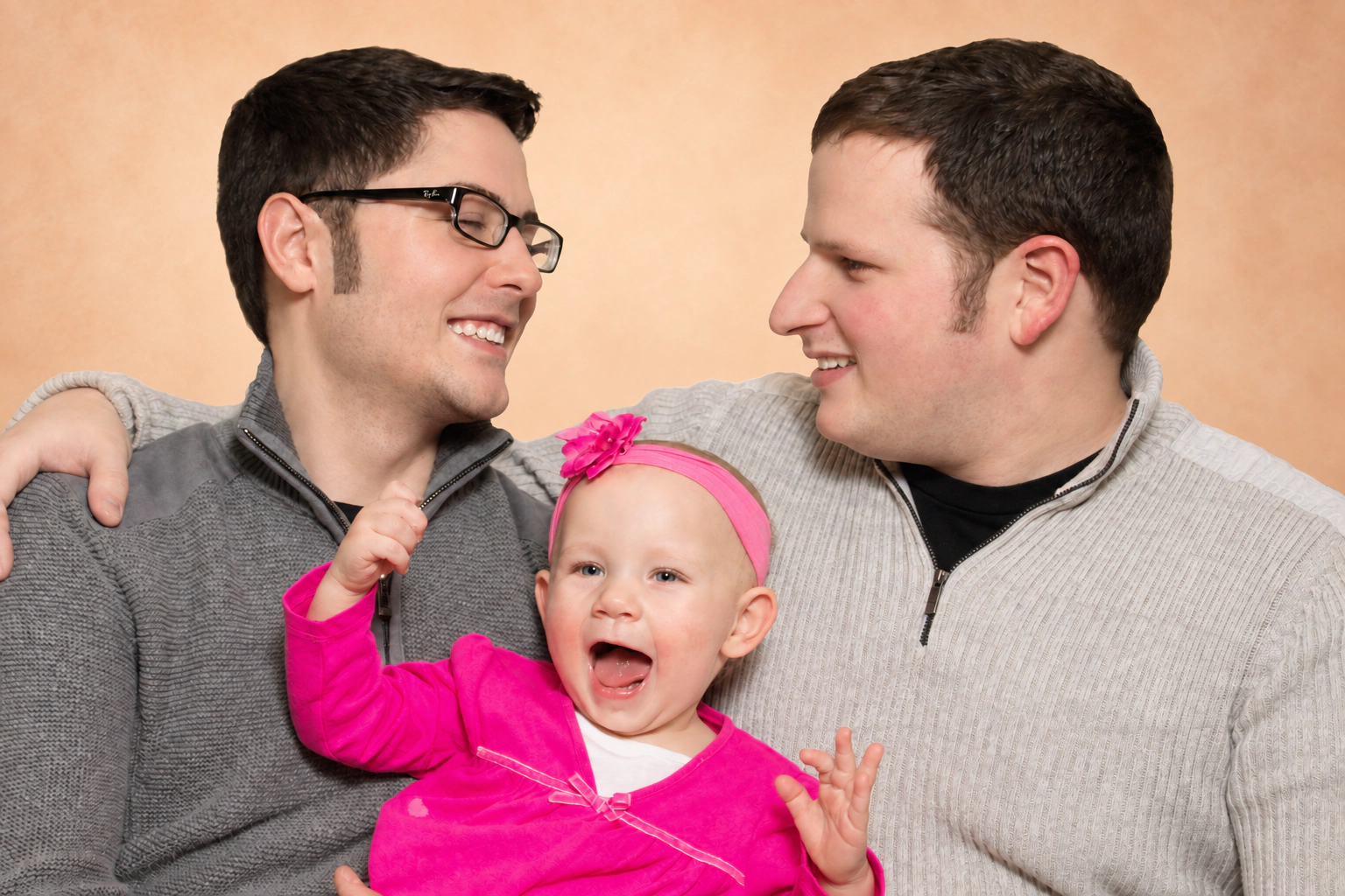 Adam and Frank Golden smiling with their daughter Sophia in 2013.
