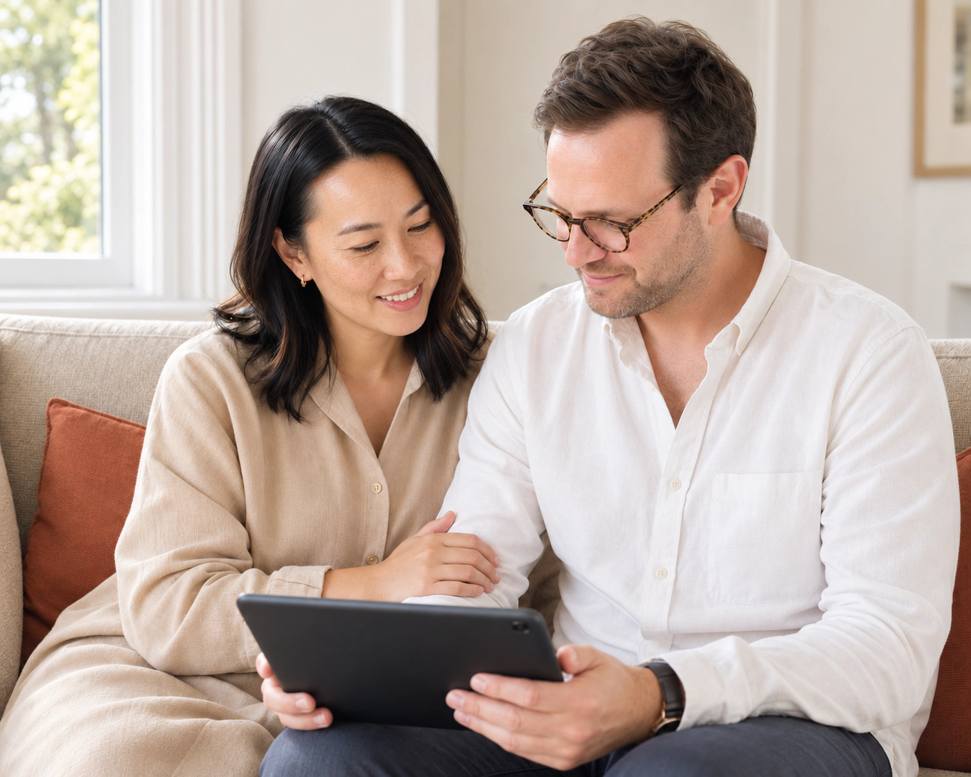 A couple reviewing a tablet together at home.