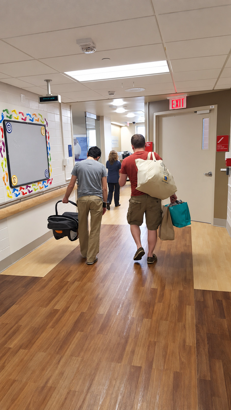 Frank and Adam Golden leaving the hospital with a newborn carrier.