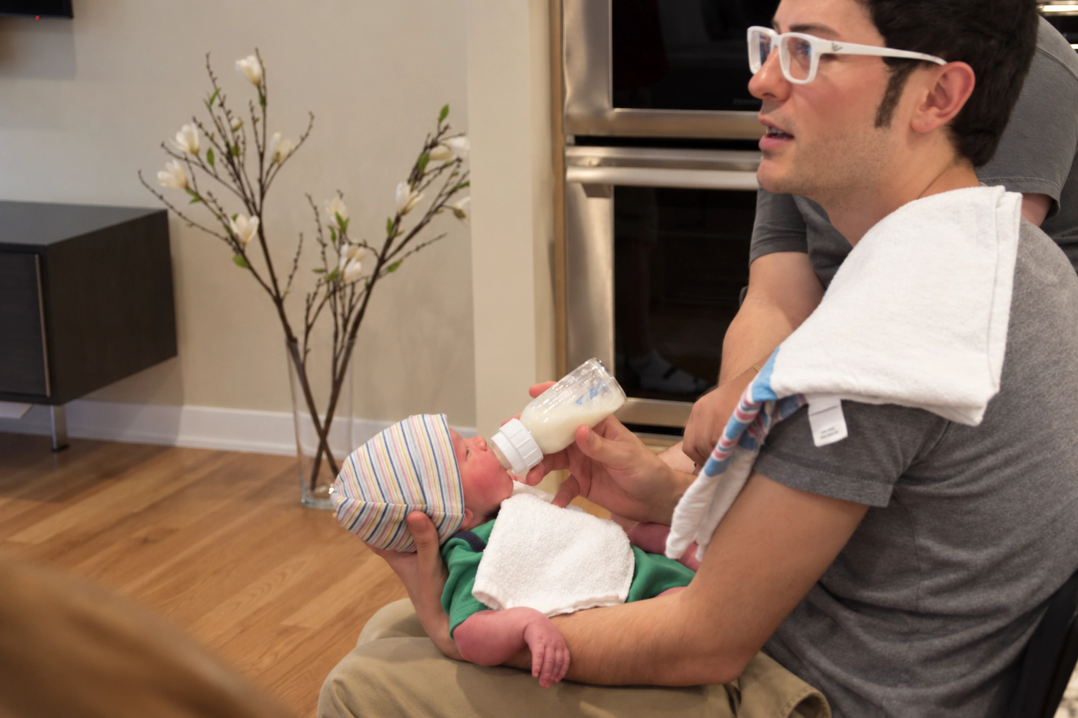 Frank Golden bottle-feeding his newborn at home.