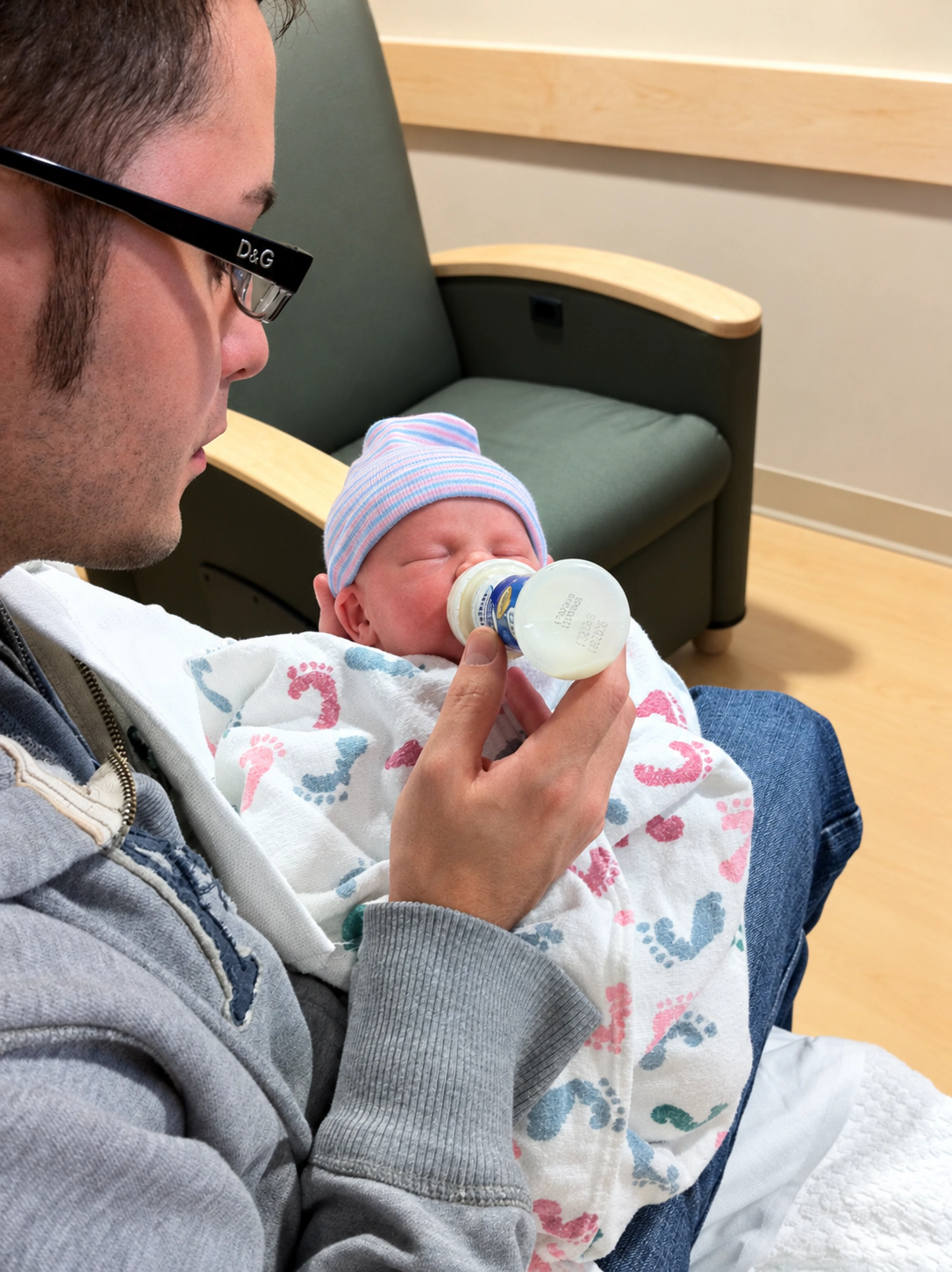 Frank Golden looking down at his newborn during a hospital feeding.