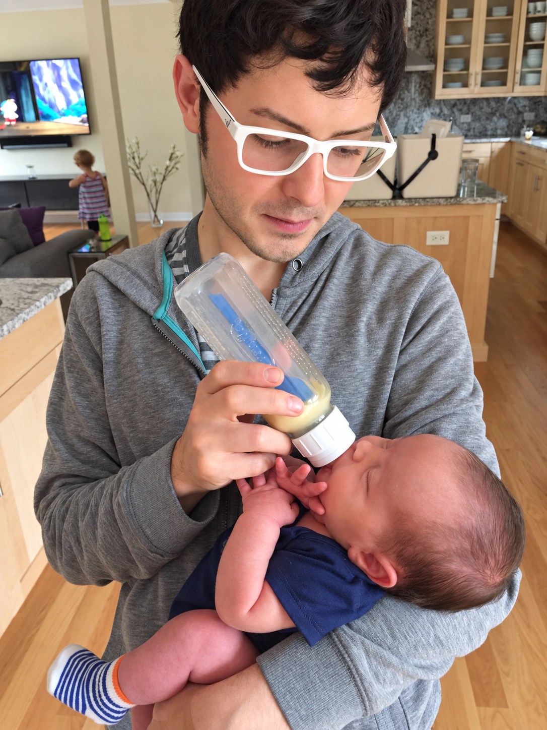 Frank Golden cradling and feeding his newborn at home.