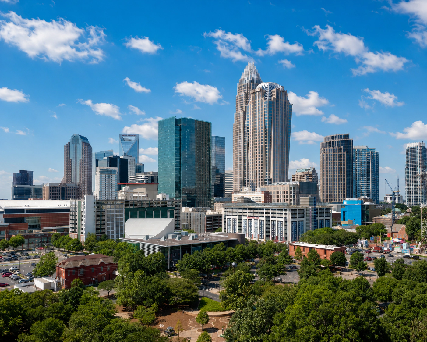 Charlotte skyline above trees and city streets in daylight.