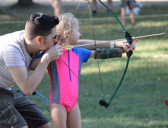 sophia-frank-archery dad teaches daughter how to shoot a bow and arrow.