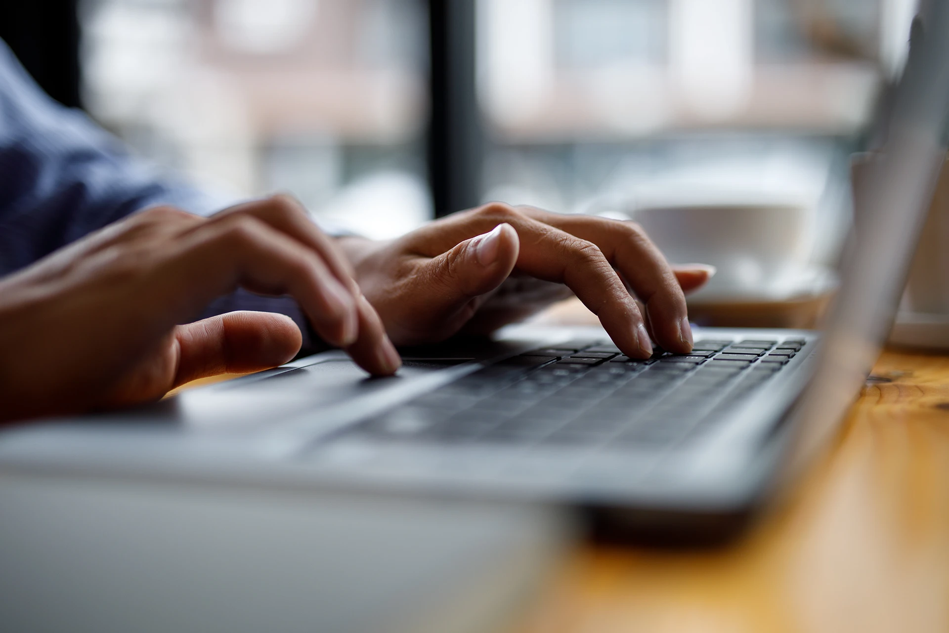 Close-up of a person researching surrogacy agencies on a laptop.