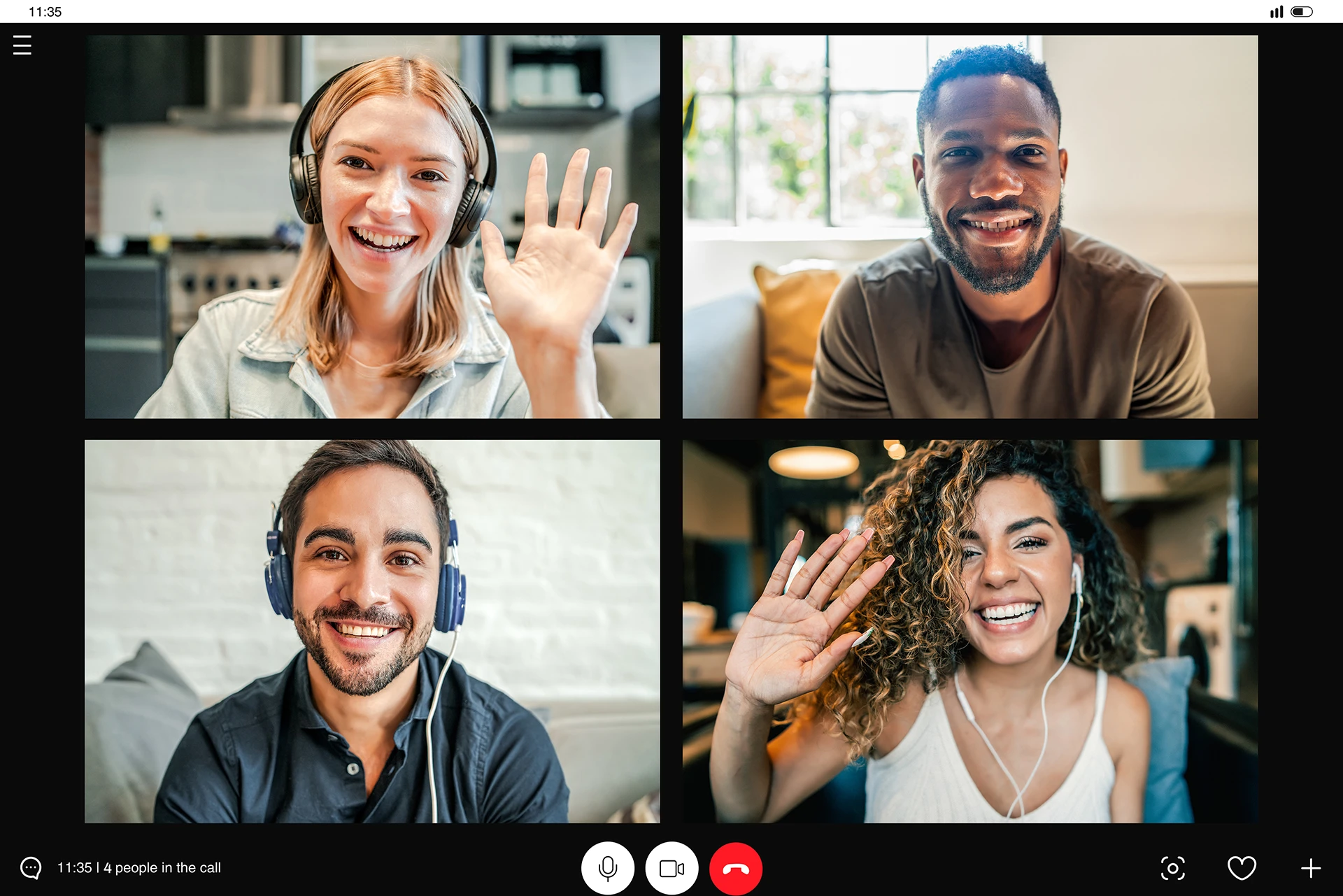 Four individuals on a video call with each other. They are smiling and waving as the call is in progress.