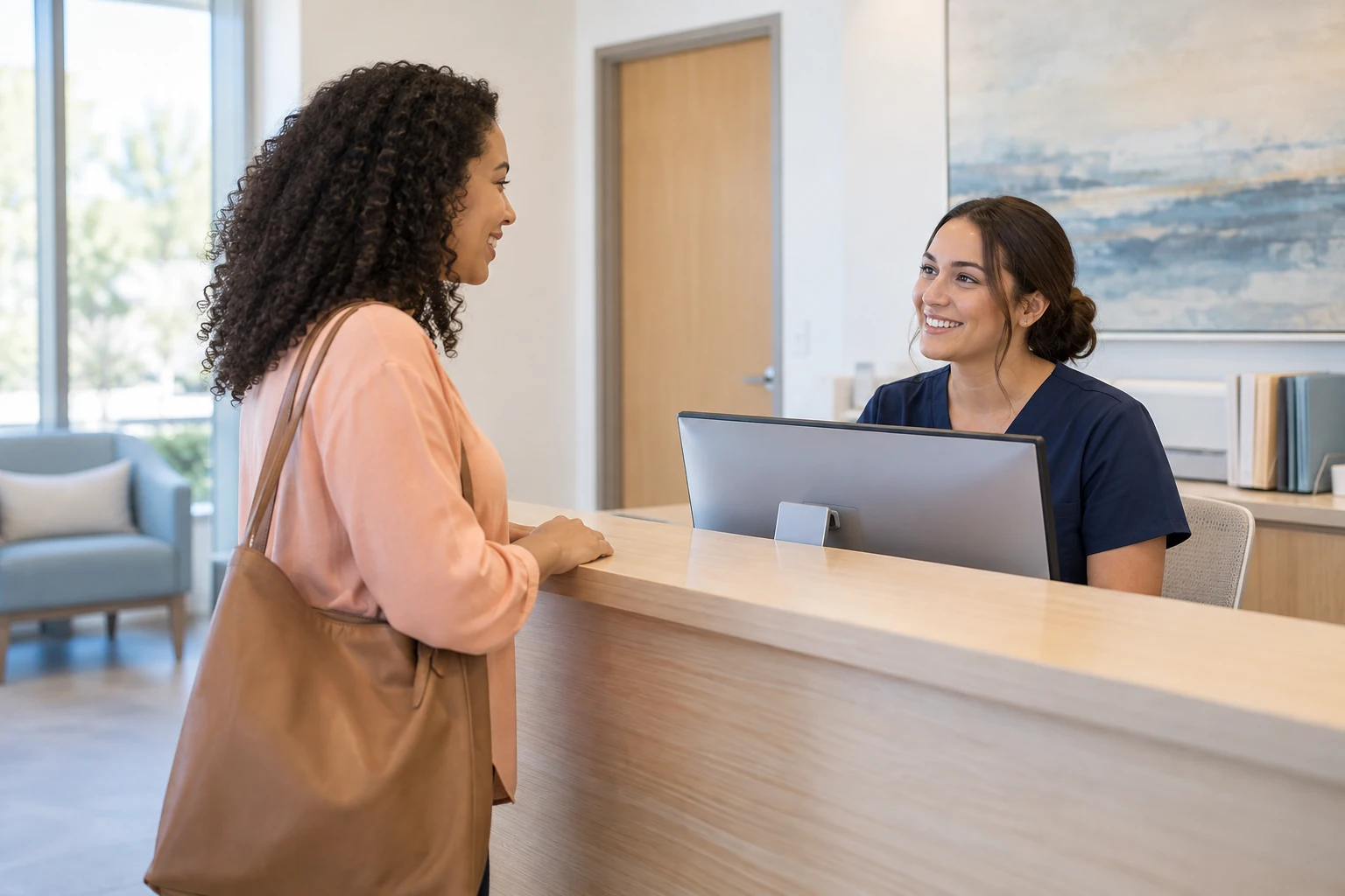 A woman checks in with a receptionist at a bright clinic reception desk.